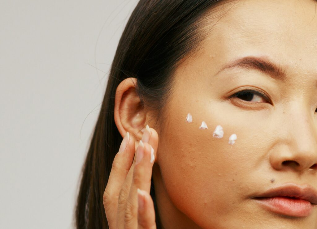 Skincare cream applied to the face as a personal care application of anhydrous lanolin.