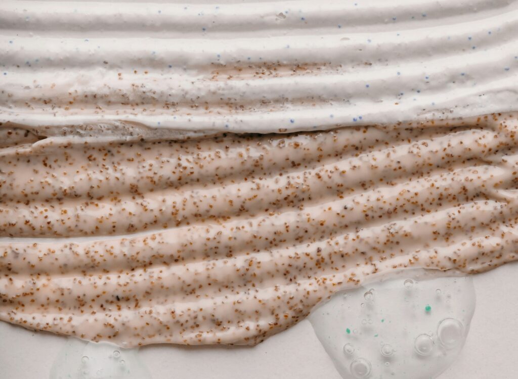 Close-up of textured cosmetic cream with brown granules, illustrating lanolin in cosmetic formulations.