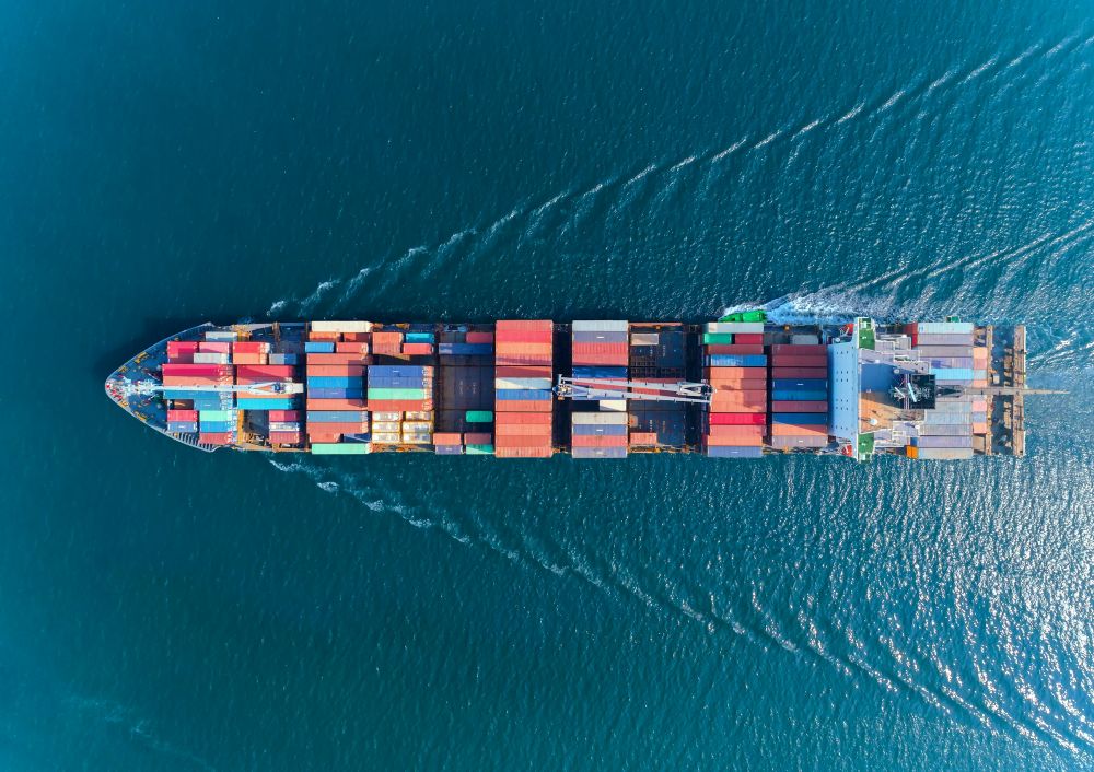 Aerial view of a container ship at sea, illustrating international transport and supply chain traceability.